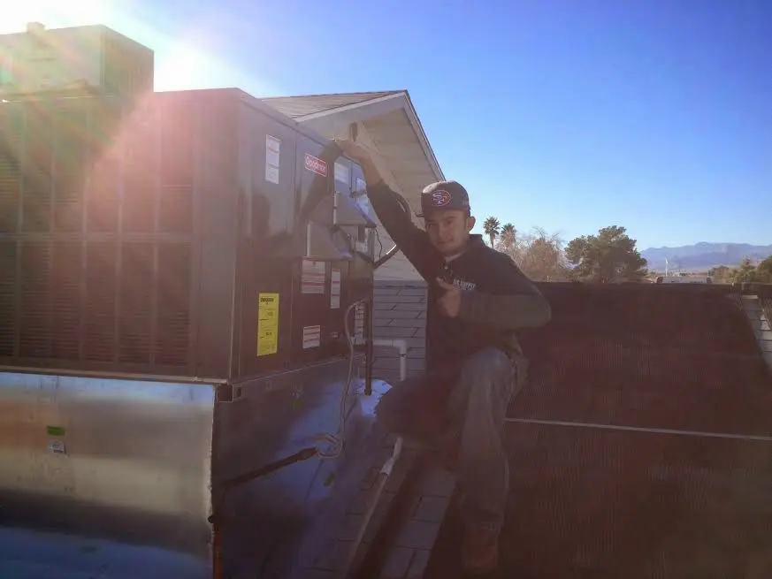 HVAC technician performing Boiler Repair on a rooftop unit in Canton